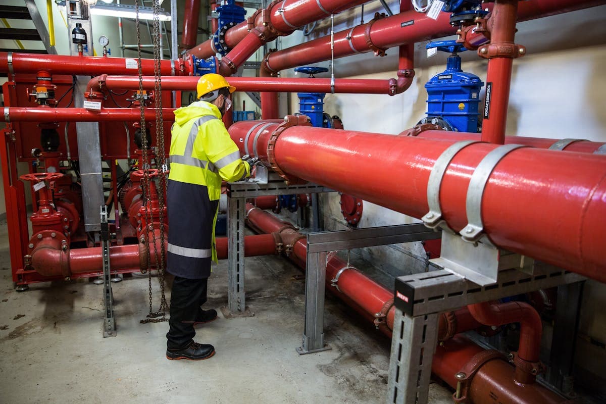 Technician servicing piping in a commercial mechanical room